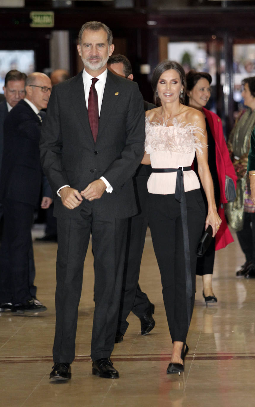 Durante el concierto en el Auditorio de Oviedo y en la noche previa a los premios Princesa de Asturias, la reina lució este precioso top de plumas en color rosa palo de la firma Antonio Burillo (The 2nd Skin&Co) conjuntado con unos pantalones de pinza en color negro.