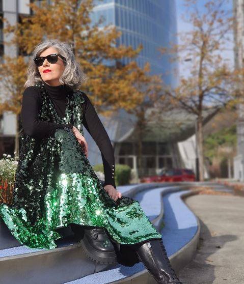 Carmen Gimeno se atreve con las mezclas atrevidas como esta de botas altas militares, jersey básico y vestido de lentejuelas en color verde.