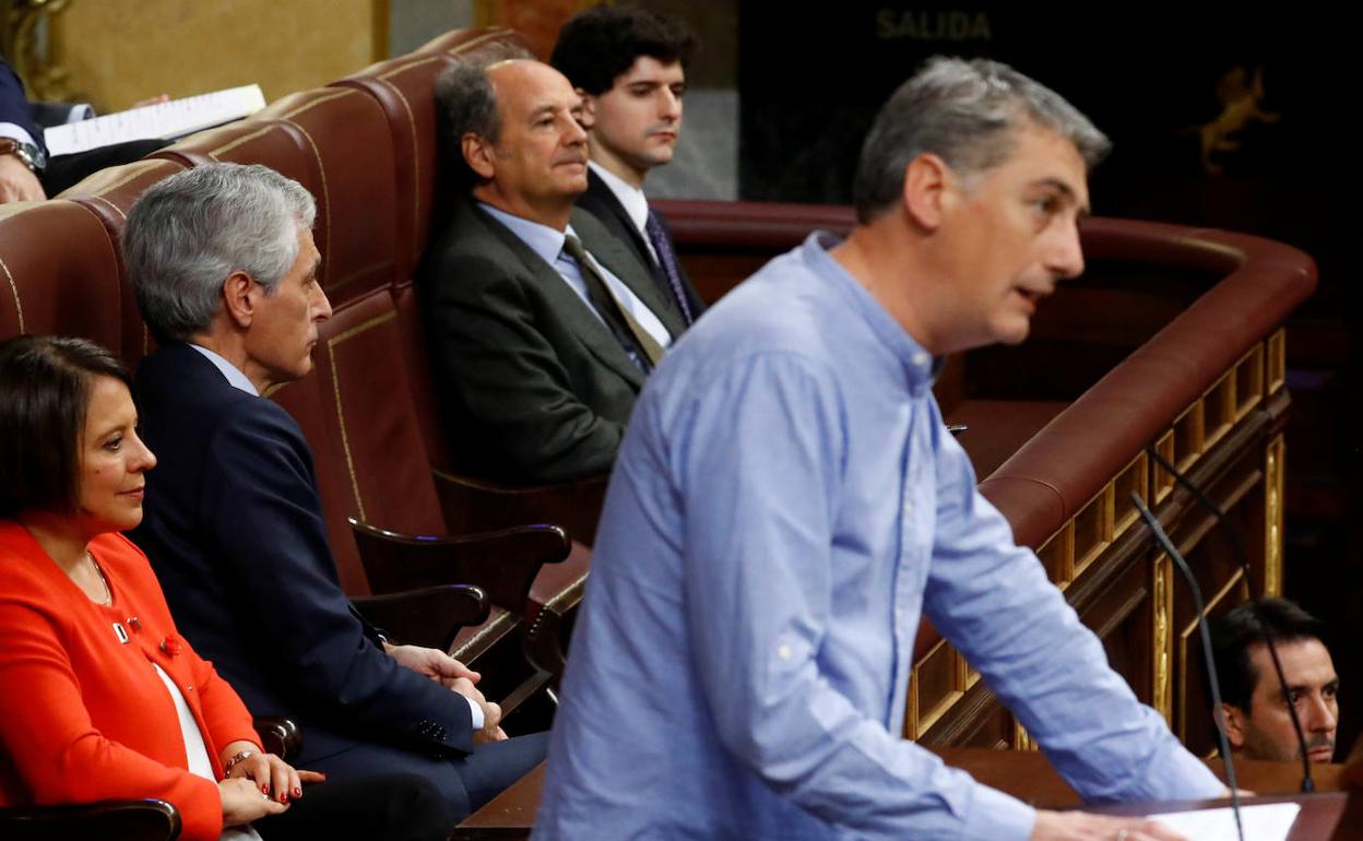 El diputado de EH Bildu Oskar Matute interviene en el pleno del Congreso, mientras que por detras le da la espalda el diputado del PP Adolfo Suárez.