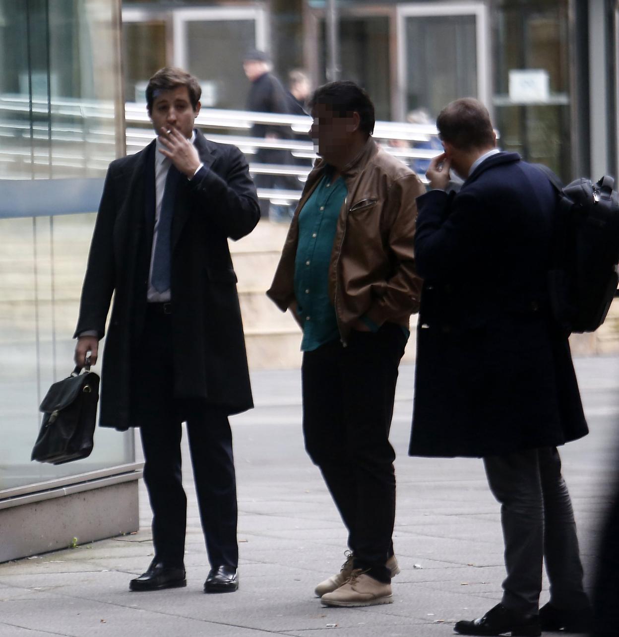 El acusado, en el medio, antes de entrar a los juzgados. 