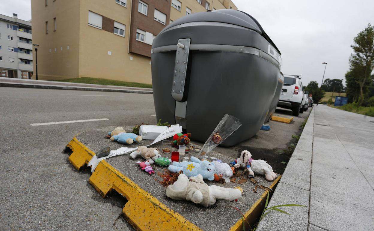 Peluches y flores junto al contenedor donde apareció el cadáver del bebé en Nuevo Roces.