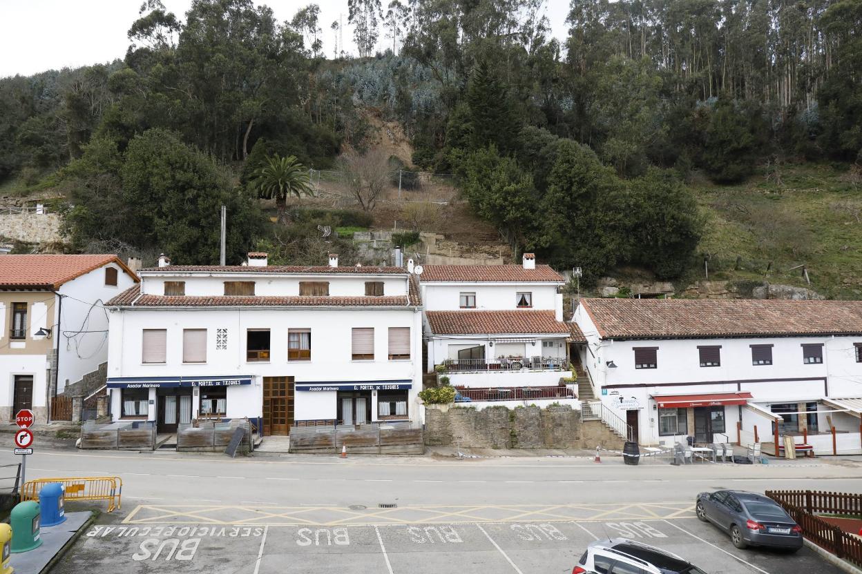 Las viviendas afectadas por el desprendimiento y, tras ellas, la barrera protectora recientemente colocada. 