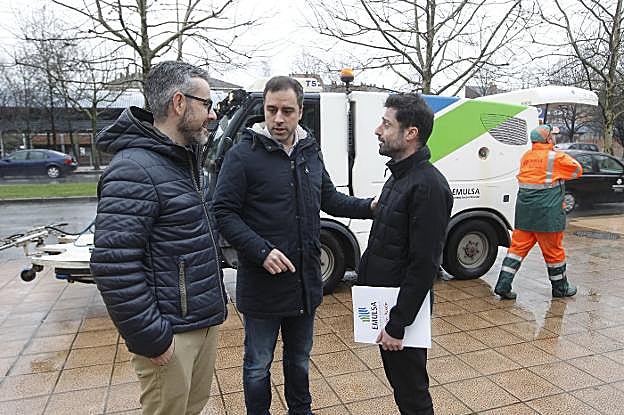 Santiago García, jefe de servicio de Higiene Urbana, departe con el concejal Olmo Ron y el gerente de Emulsa, Alfonso Baragaño, durante la presentación de plan de refuerzo en los barrios. 