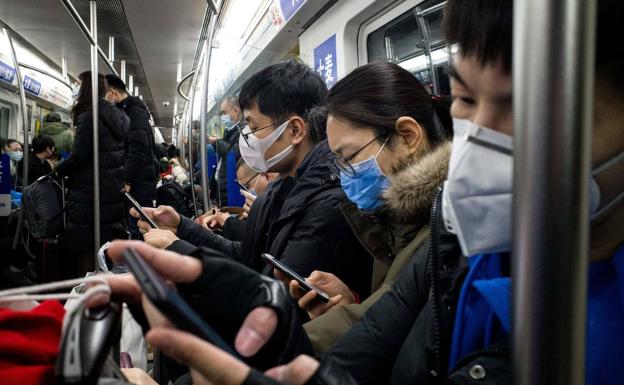 Los ciudadanos se protegen del coronavirus con mascarillas en el metro de Pekín.