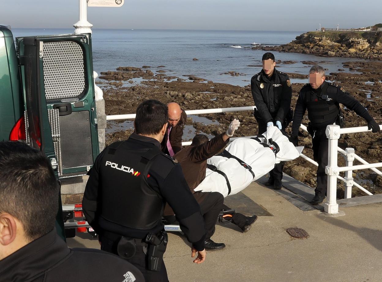 Tres agentes retiran el cadáver de la playa de El Rinconín por la escalera 24. 