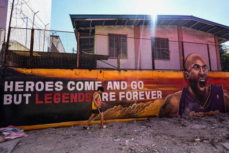 Un niño pasea con una pelota frente a la pared dedicada a Kobe Bryand. 