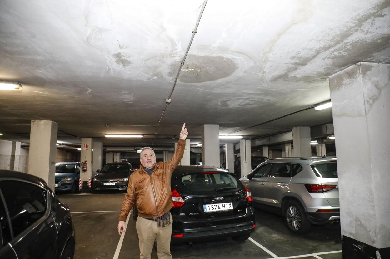 Jesús Blanco señala las humedades en el aparcamiento del bloque de donde reside. 