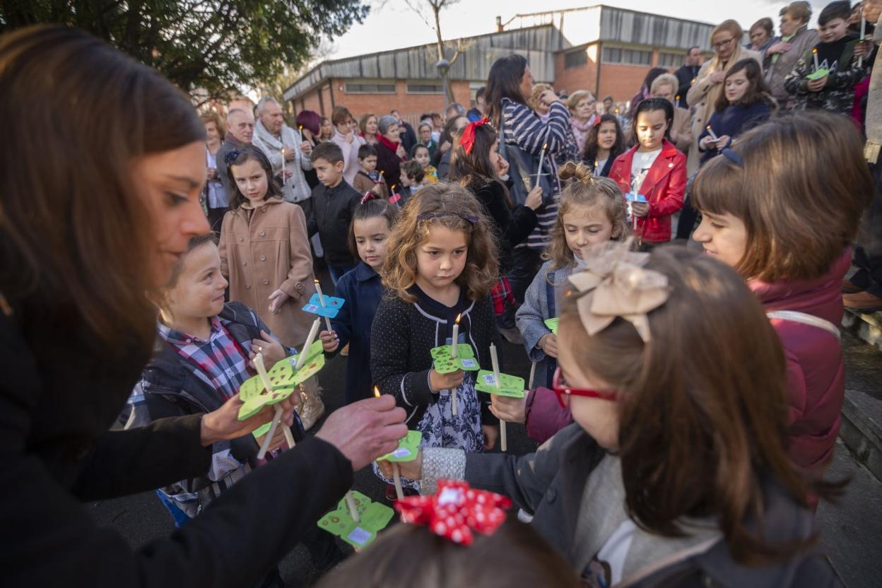 Alrededor de un centenar de niños encienden las velas que portan en palmatorias realizadas por ellos mismos. 