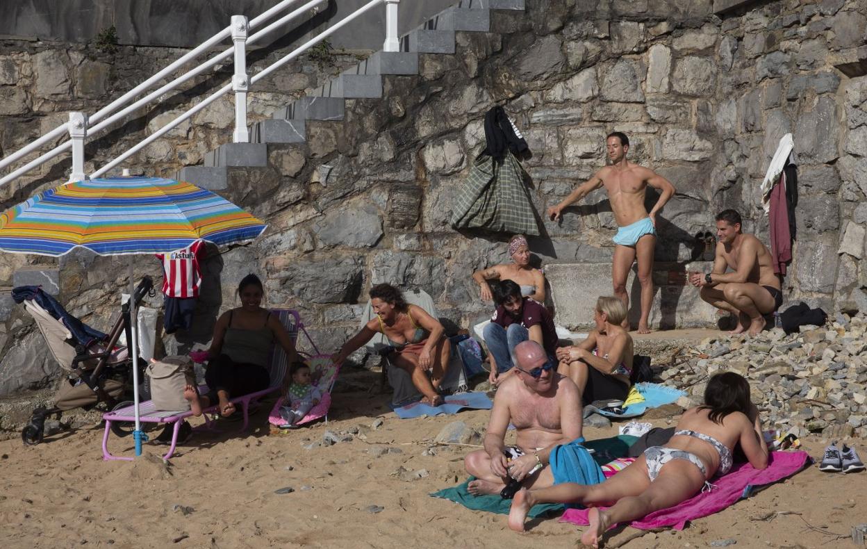 Los visitantes habituales de la zona del Tostaderu, en la playa San Lorenzo de Gijón, disfrutan del sol y el calor de febrero. 