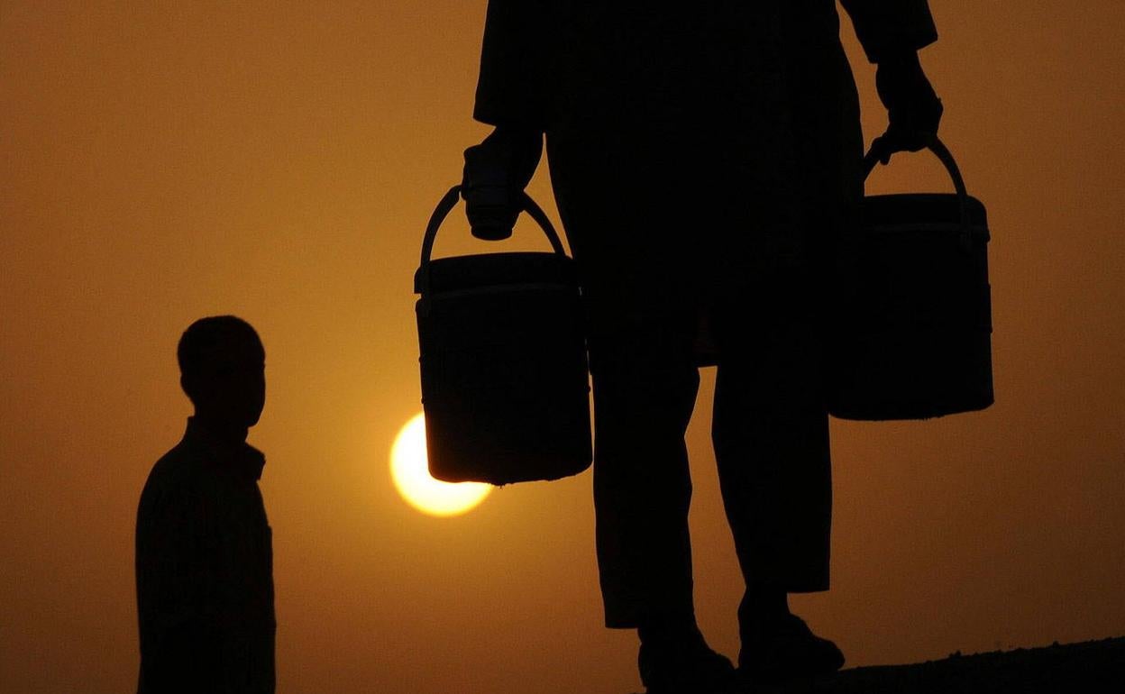 Residentes de Lahore, en Pakistán, trasladan agua durante una ola de calor.