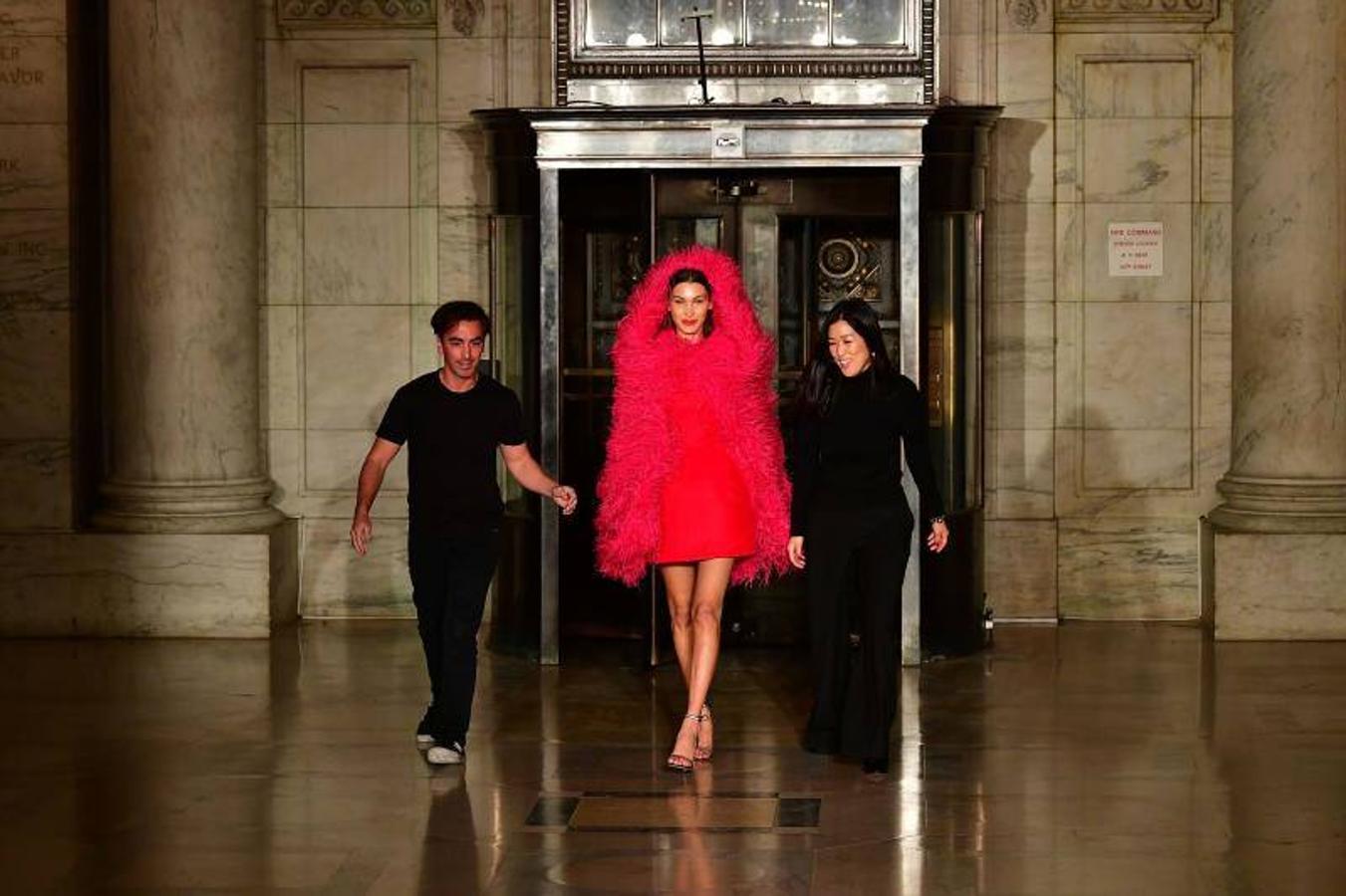 La firma de moda Óscar de la Renta deslumbró este lunes entre las paredes de mármol de la histórica Biblioteca Pública de Nueva York con un desfile en el que se presentaron elegantes propuestas de fiesta para la temporada de otoño-invierno 2020. Los diseñadores Laura Kim y Fernando García, directores creativos de la veterana marca, dejaron sin palabras con sus propuestas para la noche: decenas de vestidos majestuosos que abrazaban la silueta femenina y la embellecían a base de terciopelo, plumas, lentejuelas y adornos metalizados. La solicitada modelo Bella Hadid, fue la encargada de abrir y cerrar el 'show', que partió con looks para el día a día compuestos de pantalones, suéteres y abrigos de líneas rectas en colores brillantes, y que fue 'in crescendo' hacia las ocasiones más especiales, para las que abundaron los vestidos cortos y reveladores, o largos y con volumen.