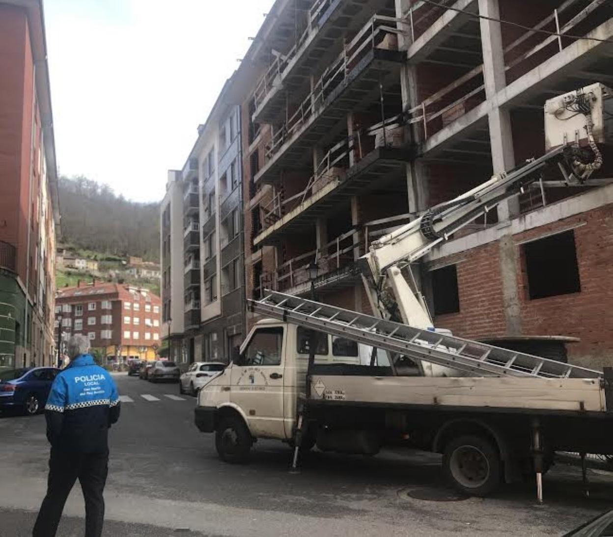 Un agente de la Policía Local de San Martín supervisa los trabajos de desmontaje de los cierres. 