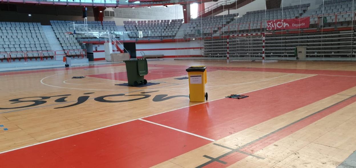 Dos contenedores colocados en mitad de la pista del Palacio de Deportes para recoger el agua de las goteras, durante las lluvias del pasado fin de semana. 