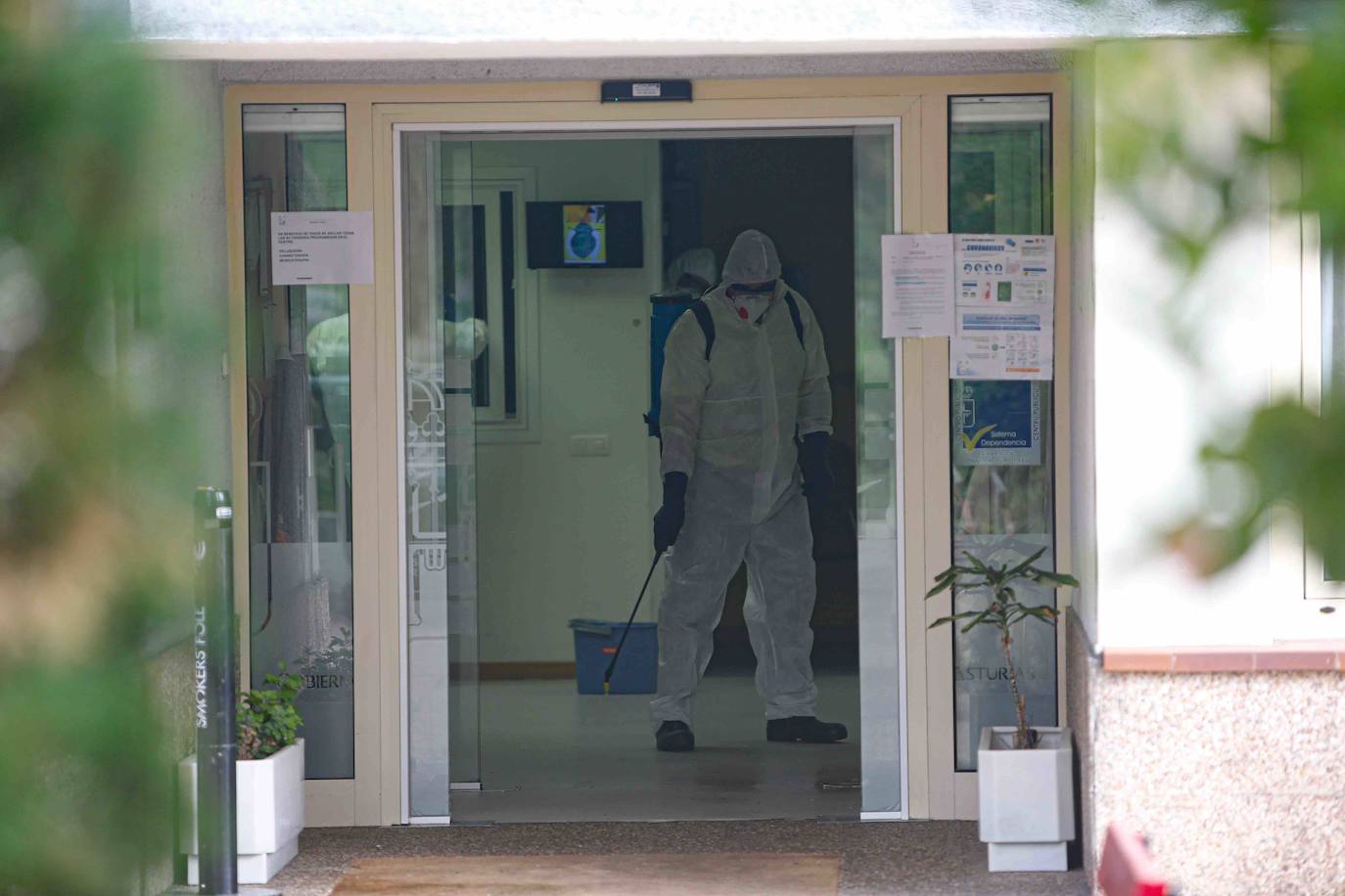 Trabajadores y personal de Tragsa desinfectan las instalaciones de la residencia del ERA en Grado.