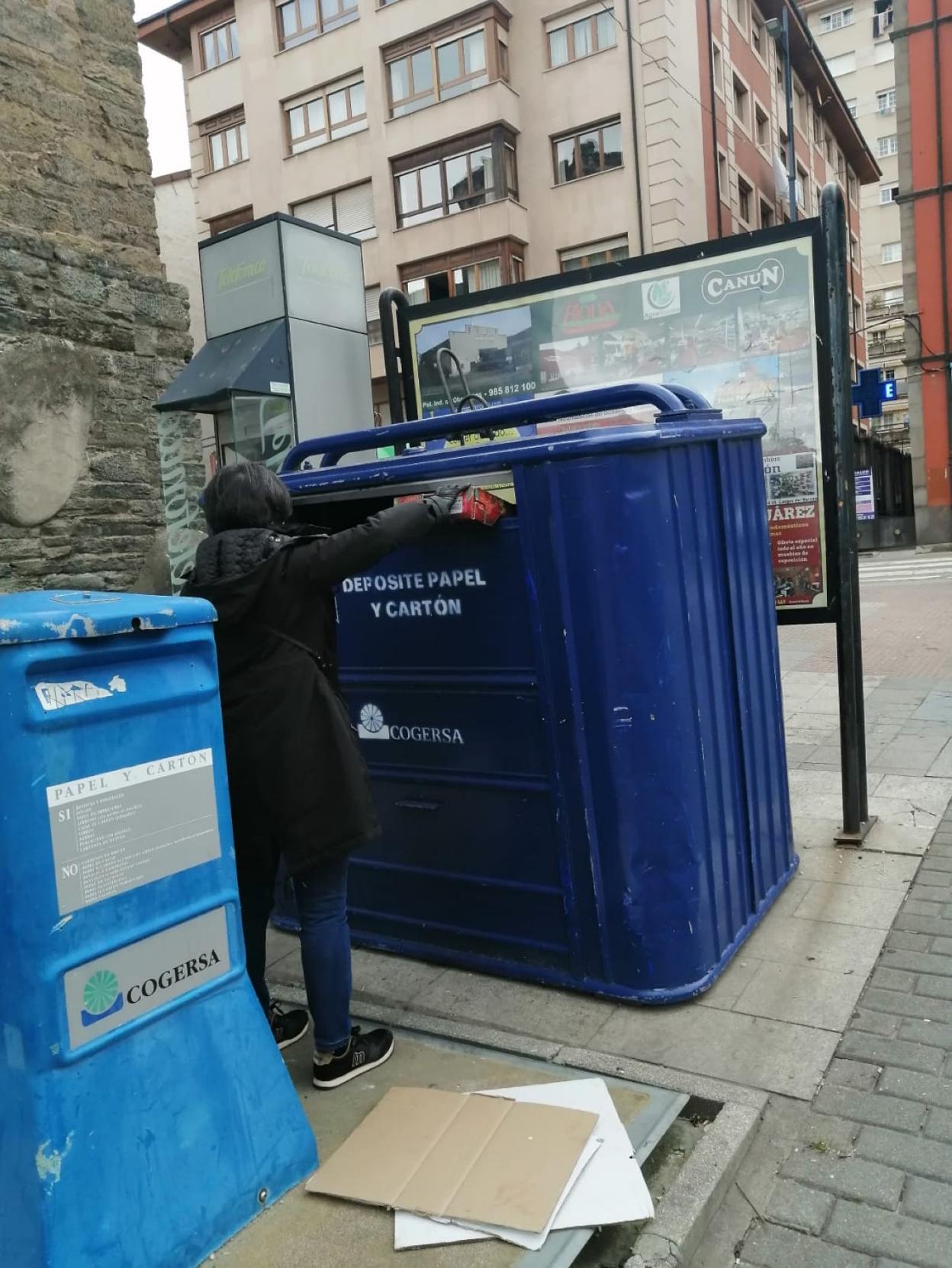 Una vecina deposita el cartón en un contenedor azul de Cangas del Narcea. 