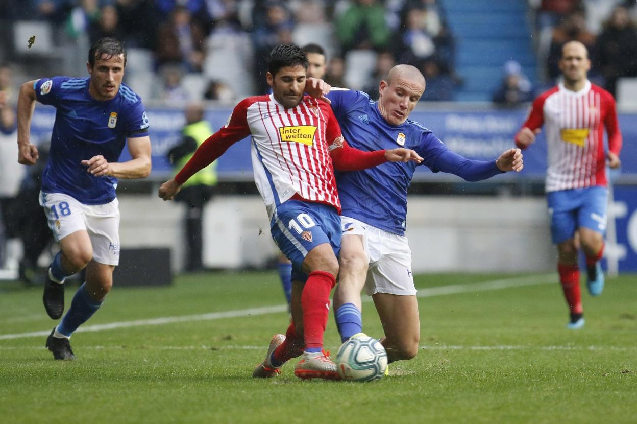 El oviedista Lolo trata de adelantarse al sportinguista Carmona en el primer derbi de la temporada. 