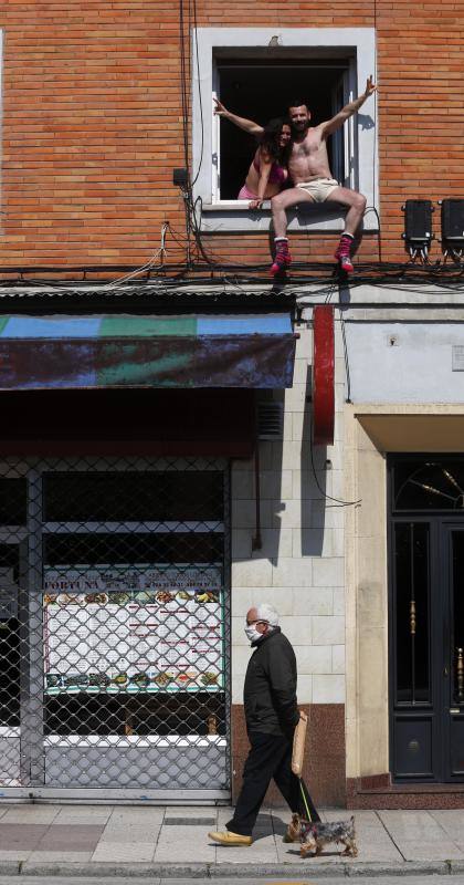 El confinamiento por el coronavirus obliga a reinventar técnicas de socialización. Tanto los asturianos como el resto de españoles no dudan en asomarse al balcón para ver algún rayo de sol, leer o, incluso, tomar el vermú con los vecinos. 