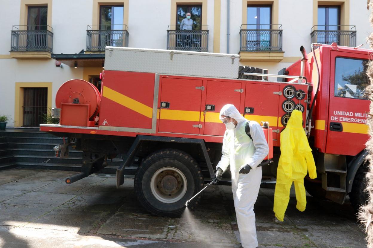 Uno de los efectivos realiza tareas de desinfección en el exterior de la residencia Virgen del Carbayo. 