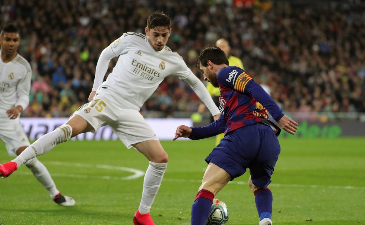 Valverde intenta frenar a Messi en una acción del último clásico. 