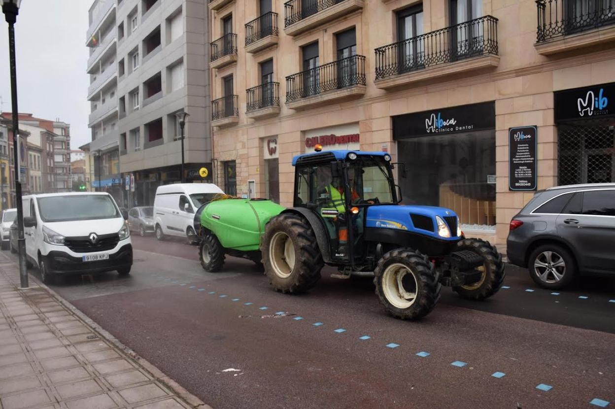 El tractor cedido por los llagares desinfectando ayer la calle polesa de Florencio Rodríguez. 