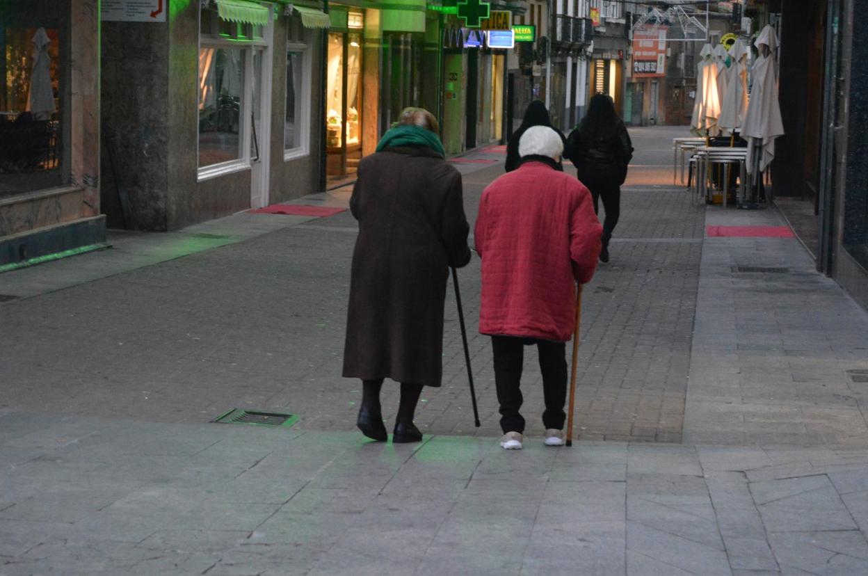 Dos ancianas pasean por la calle Mayor de Cangas del Narcea. 