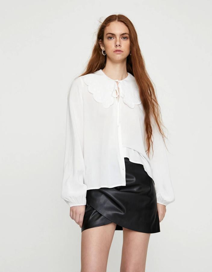 Camisa blanca con volumen en las mangas y bordados en el cuello de Pull & Bear, 9,99 euros.