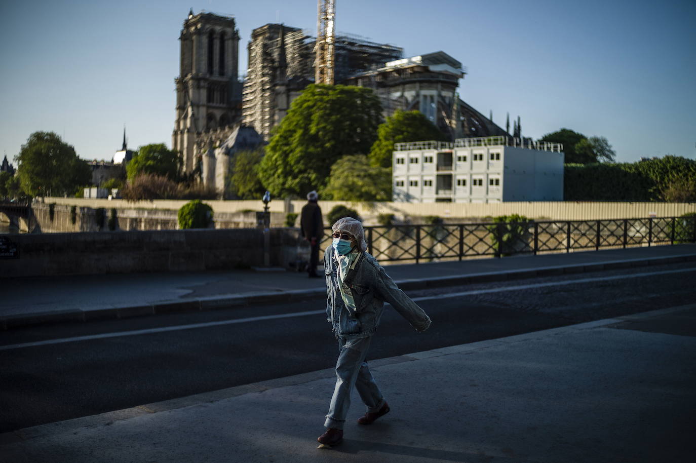 Ocho siglos de historia quedaron en suspenso cuando el 15 de abril de 2019 un incendio derribó la aguja de Notre Dame y su cubierta. Un año después, Francia persiste en su objetivo de reabrir la catedral en 2024, aunque el coronavirus mantenga paralizadas las obras. Las vallas que rodean el templo parisino, la grúa sin movimiento y los andamios que velan por su estructura son reflejo de aquella fatídica tarde, sobre la que la Justicia todavía no ha podido esclarecer el origen de las llamas. El avance de las pesquisas y de la restauración está determinado por la pandemia que ha puesto en hibernación al mundo. Aunque la investigación judicial prosigue en manos de la Brigada Criminal, el análisis técnico se vio frenado cuando este 16 de marzo las obras se suspendieron hasta nueva orden por precaución sanitaria.