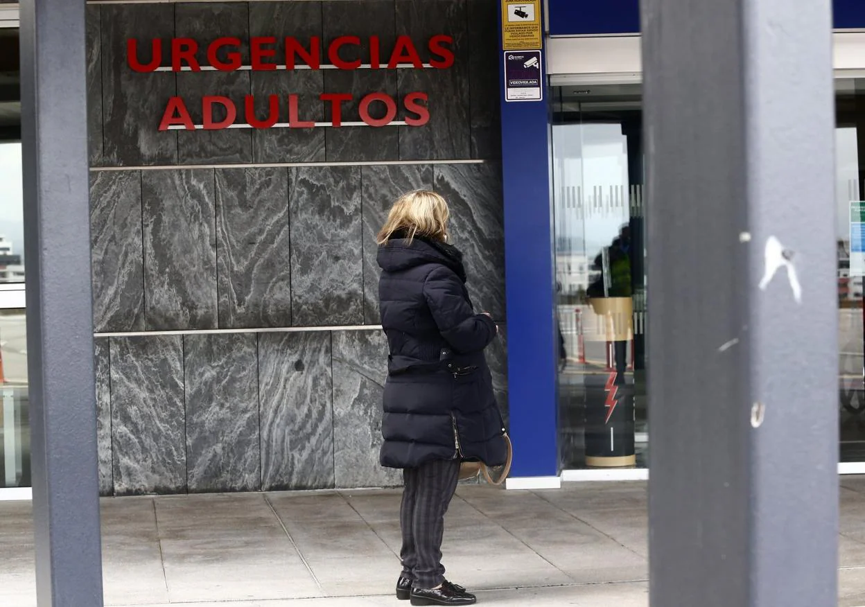 Una mujer, junto a la puerta de acceso a las Urgencias de adultos del HUCA. 