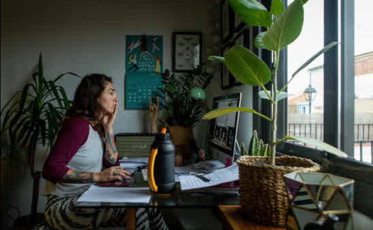 Una mujer realiza teletrabajo en su casa. 