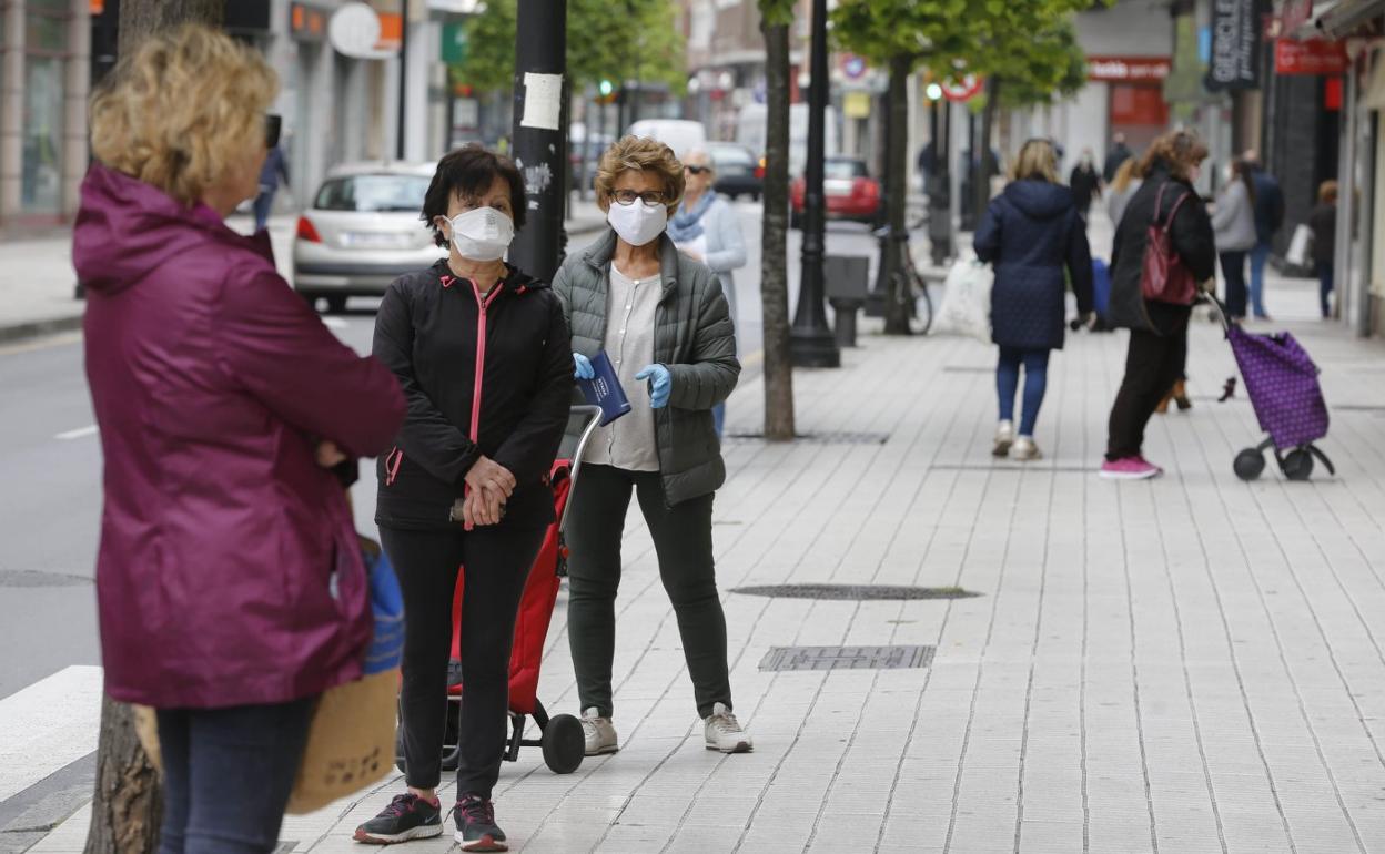 Varias mujeres, ayer, a la cola de un supermercado en una calle del centro de Gijón. 