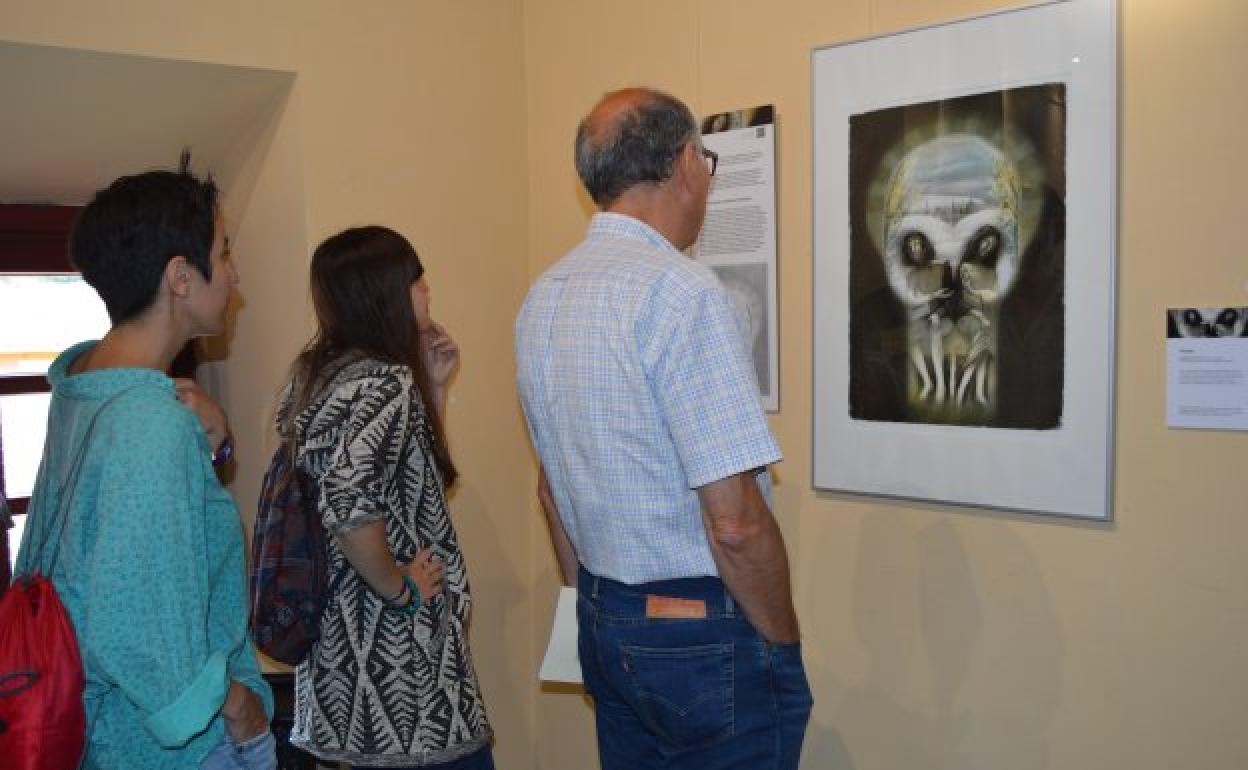 Visitantes se detienen ante una de las obras expuestas durante la UABRA. 