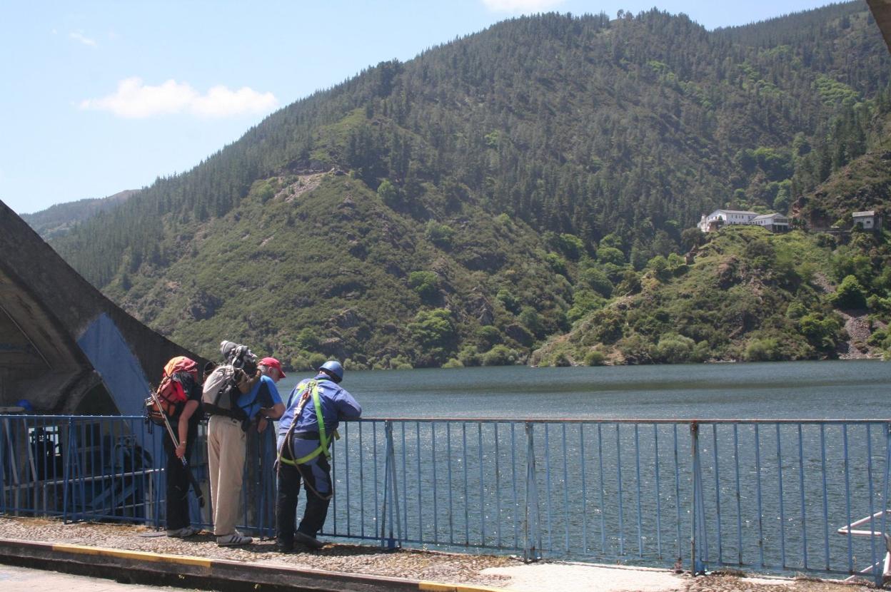 Un grupo de turistas observa el embalse de Grandas de Salime. 