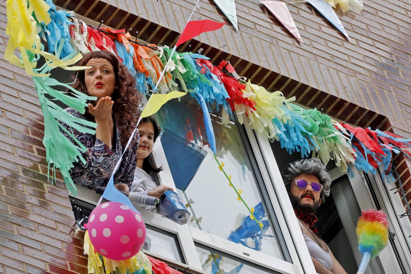 Vecinos del barrio de Contrueces se divierten este domingo desde sus ventanas emulando la estética del videoclip de Queen 'I want to break free'. 