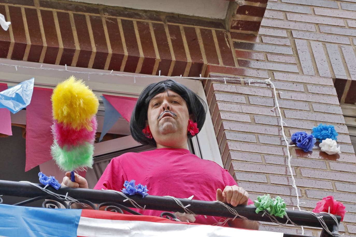 Vecinos del barrio de Contrueces se divierten este domingo desde sus ventanas emulando la estética del videoclip de Queen 'I want to break free'. 