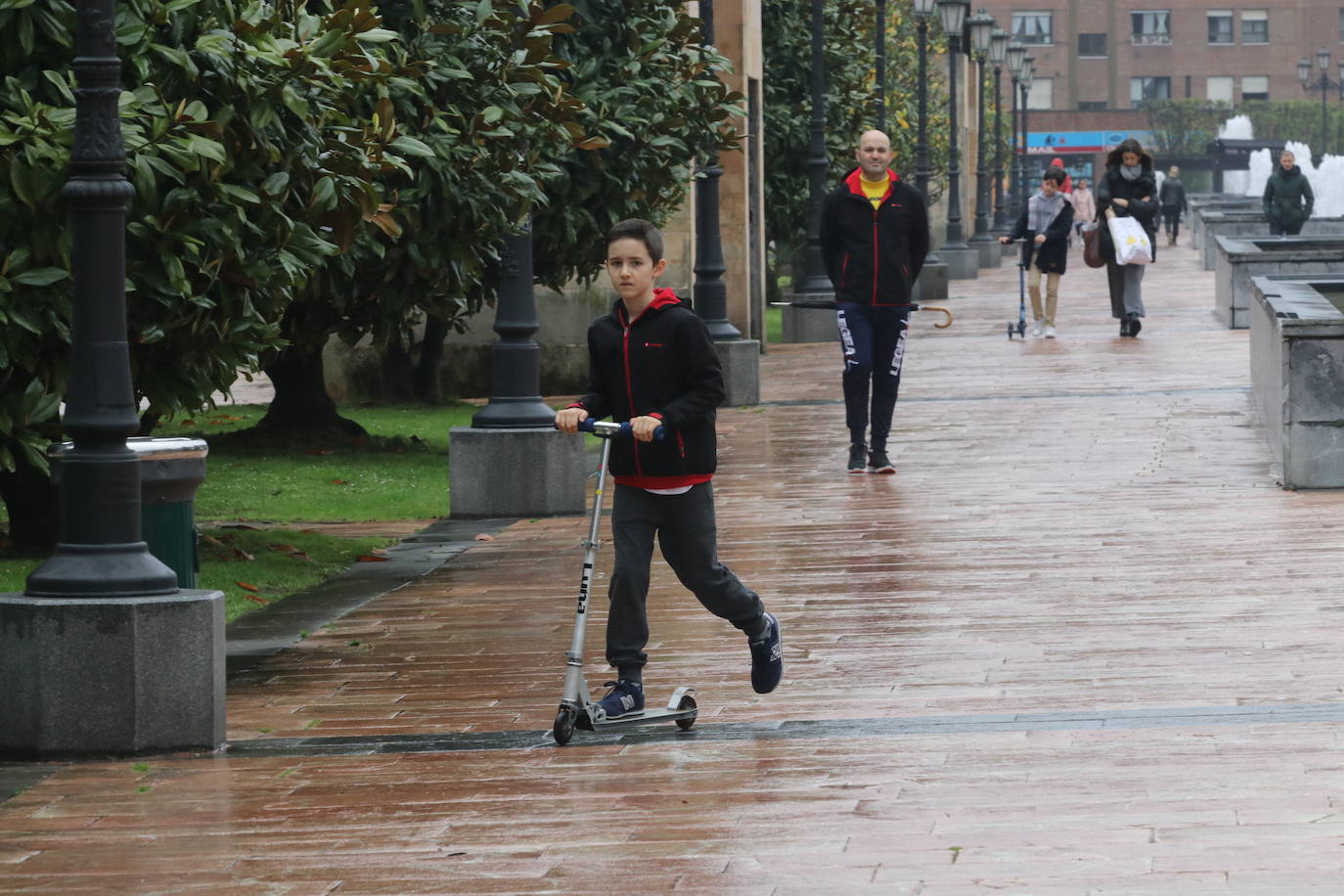 Los niños de Oviedo ponen al mal tiempo buena cara y salen a disfrutar de sus calles