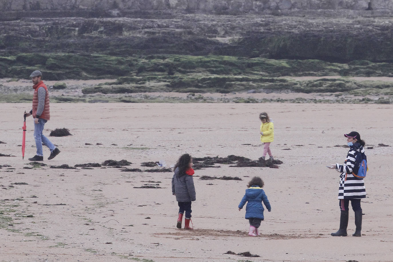 Primeros paseos bajo el orbayu en Gijón de los más pequeños