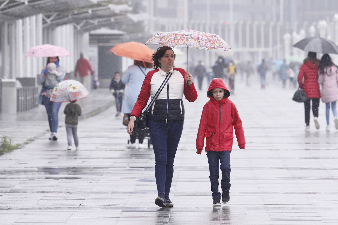 Primeros paseos bajo el orbayu en Gijón de los más pequeños