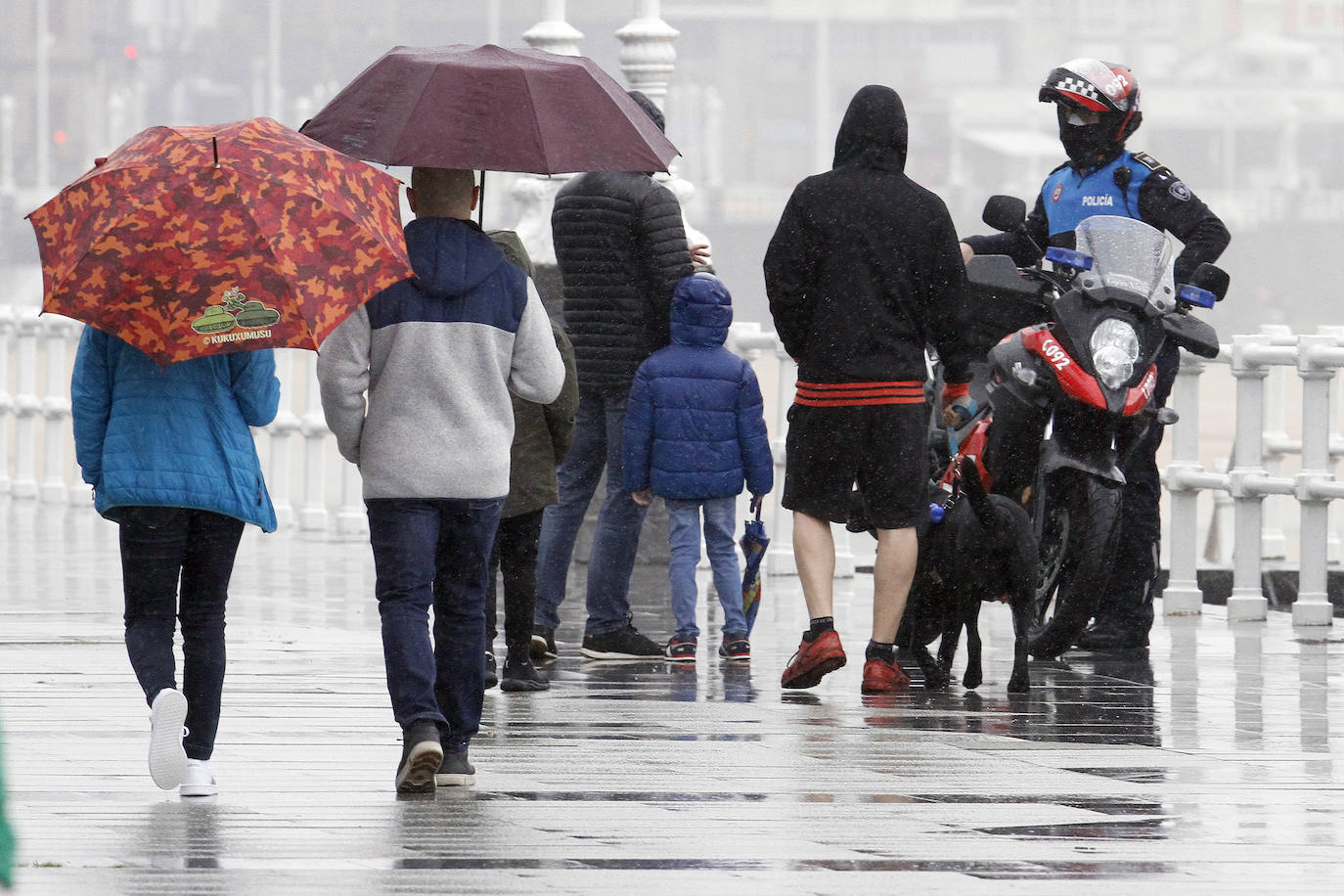 Primeros paseos bajo el orbayu en Gijón de los más pequeños