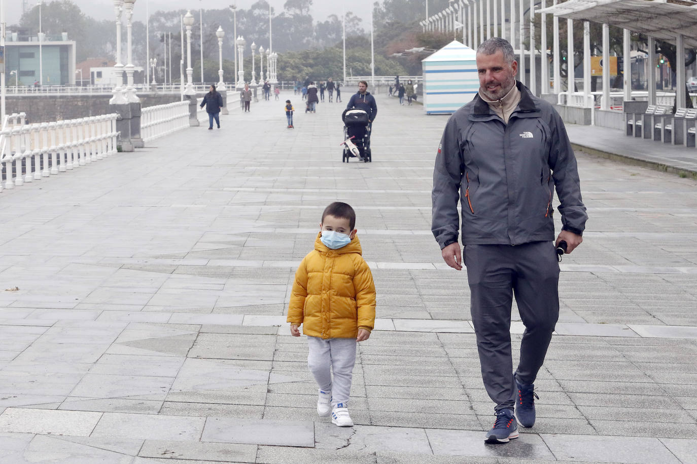 Primeros paseos bajo el orbayu en Gijón de los más pequeños