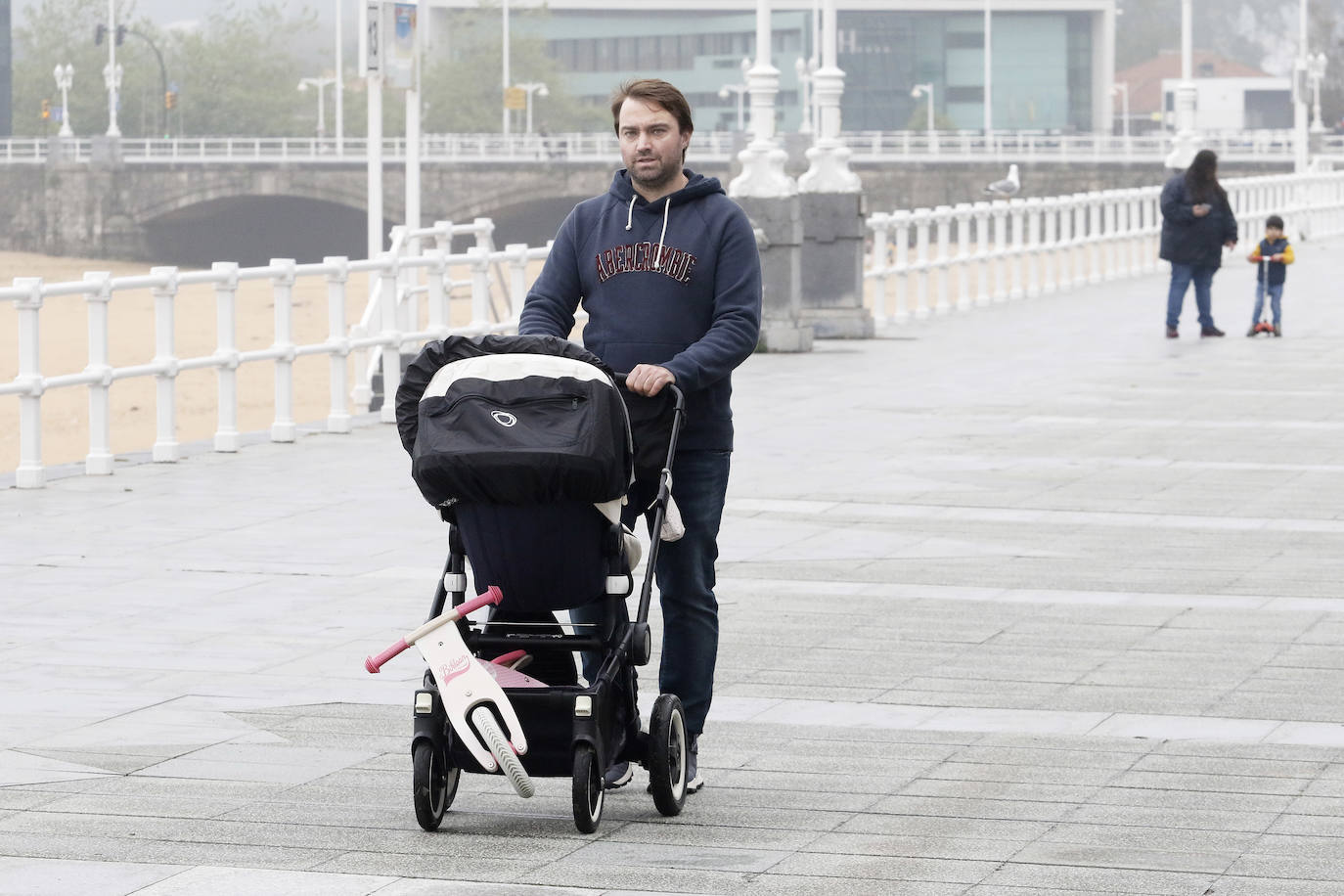 Primeros paseos bajo el orbayu en Gijón de los más pequeños