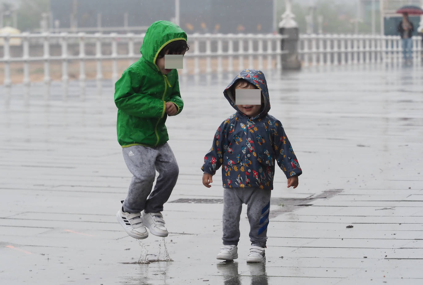 Primeros paseos bajo el orbayu en Gijón de los más pequeños