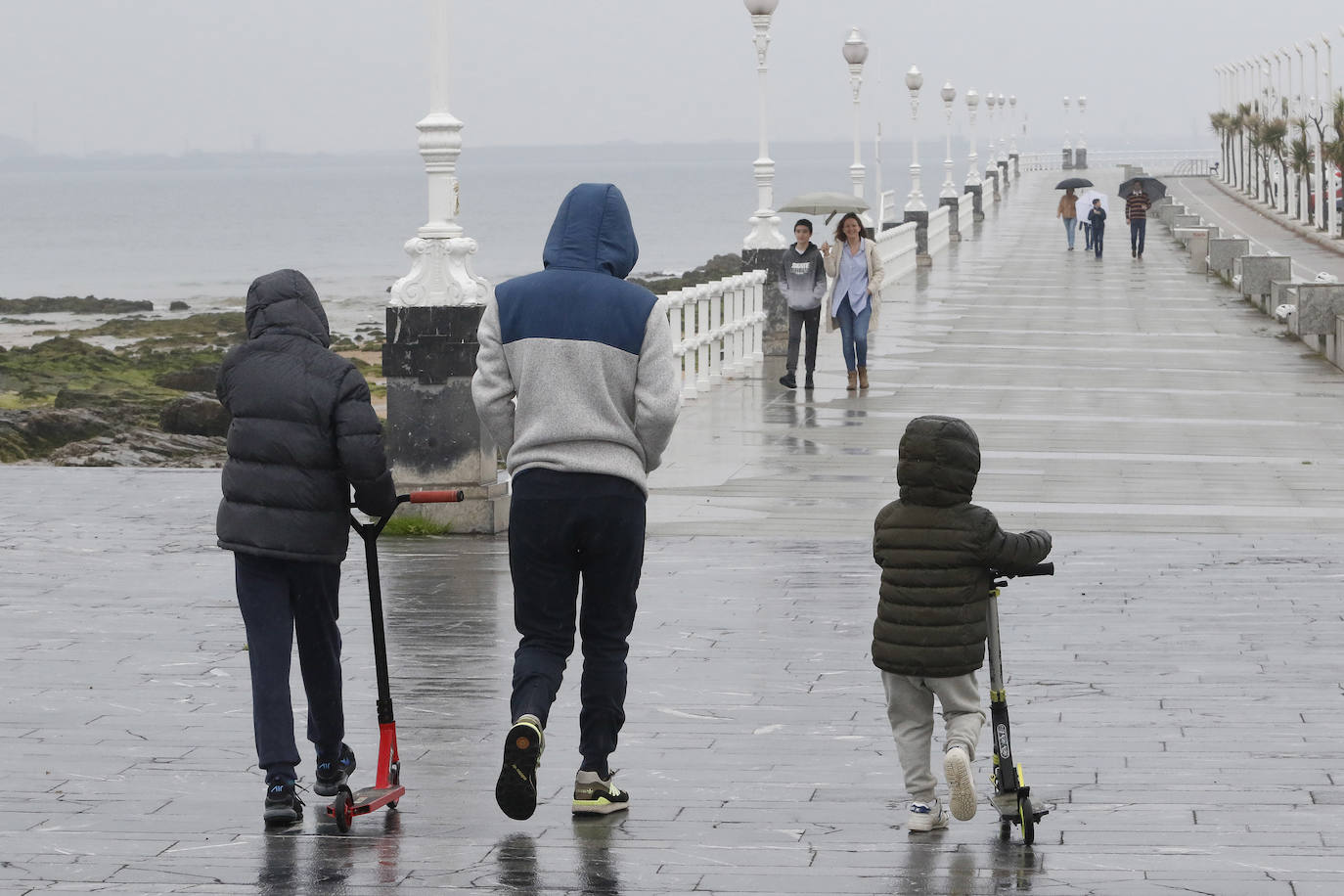 Primeros paseos bajo el orbayu en Gijón de los más pequeños