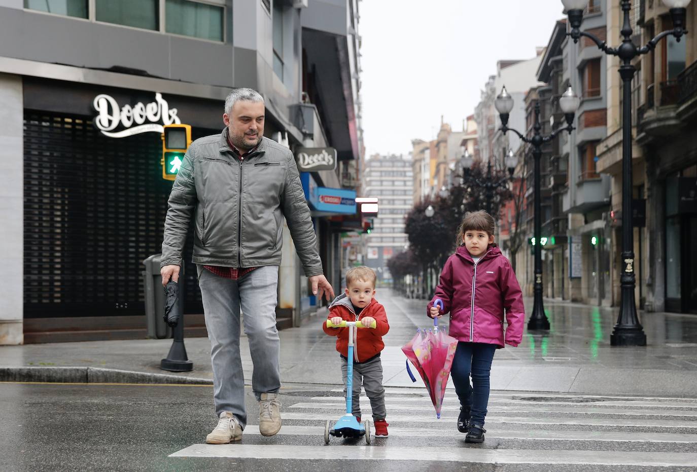 Primeros paseos bajo el orbayu en Gijón de los más pequeños