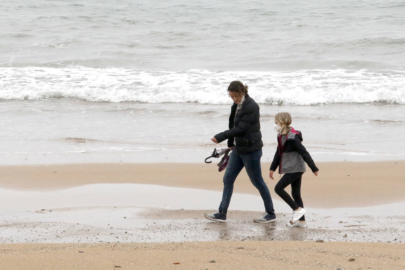 Primeros paseos bajo el orbayu en Gijón de los más pequeños