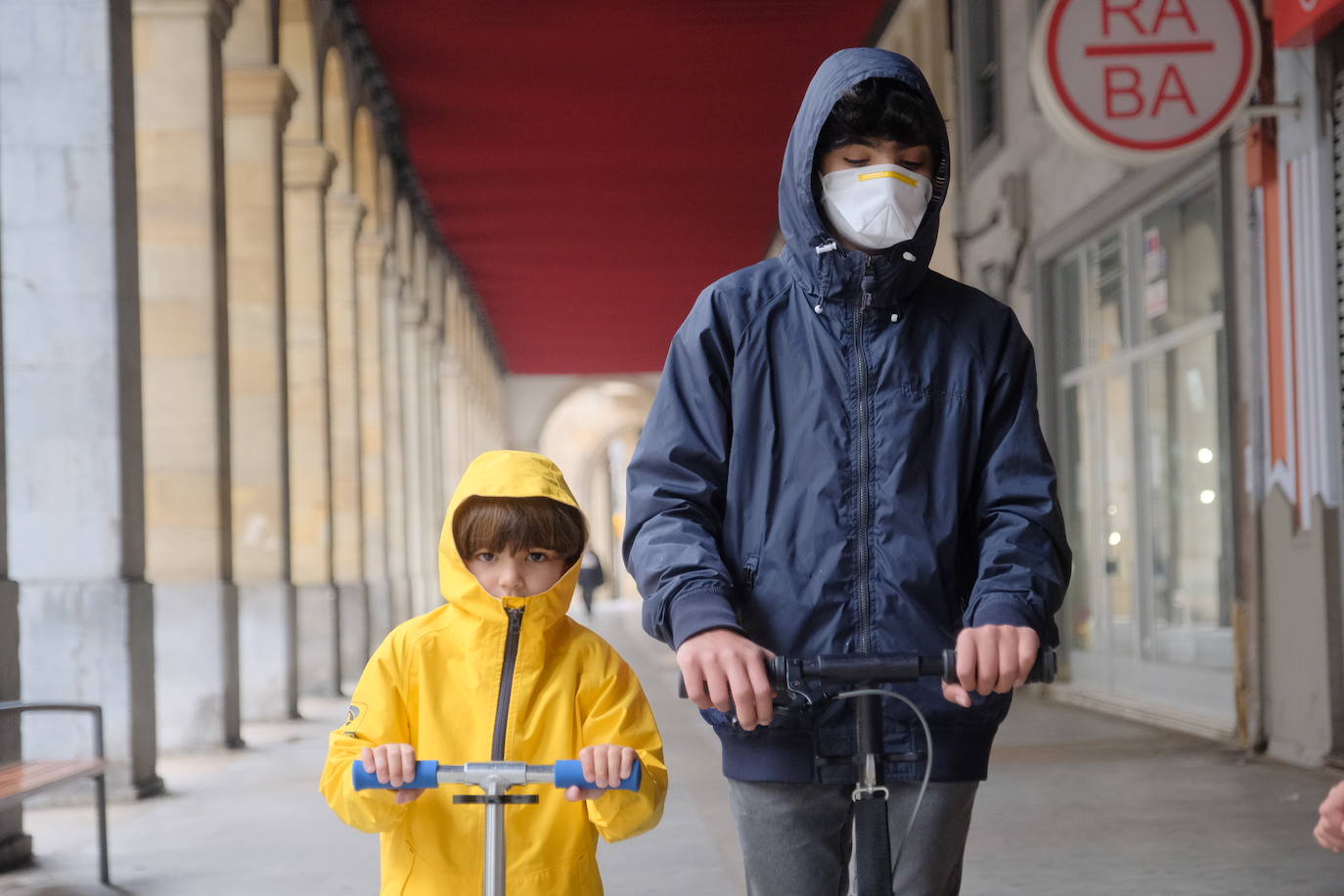 Primeros paseos bajo el orbayu en Gijón de los más pequeños