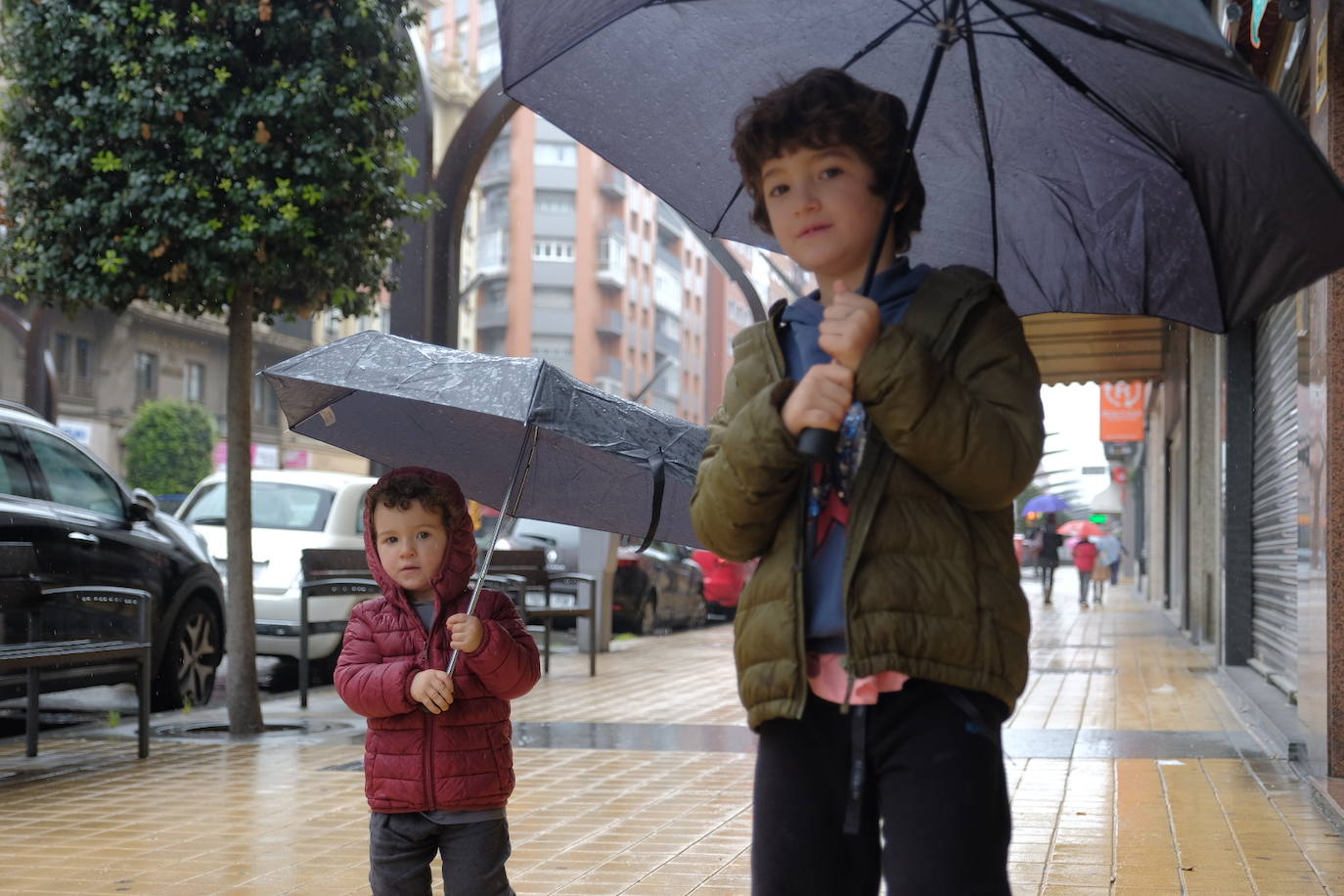 Primeros paseos bajo el orbayu en Gijón de los más pequeños