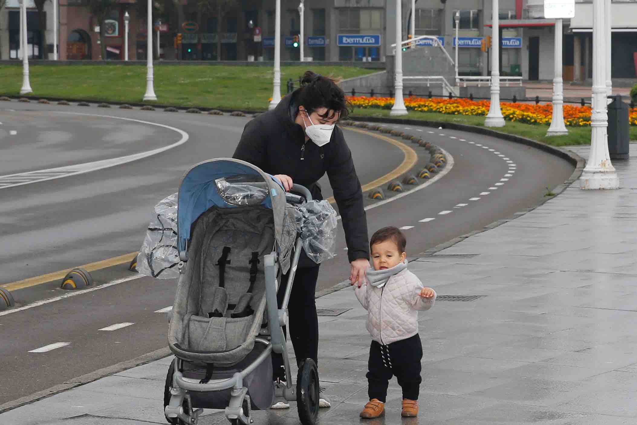 Primeros paseos bajo el orbayu en Gijón de los más pequeños