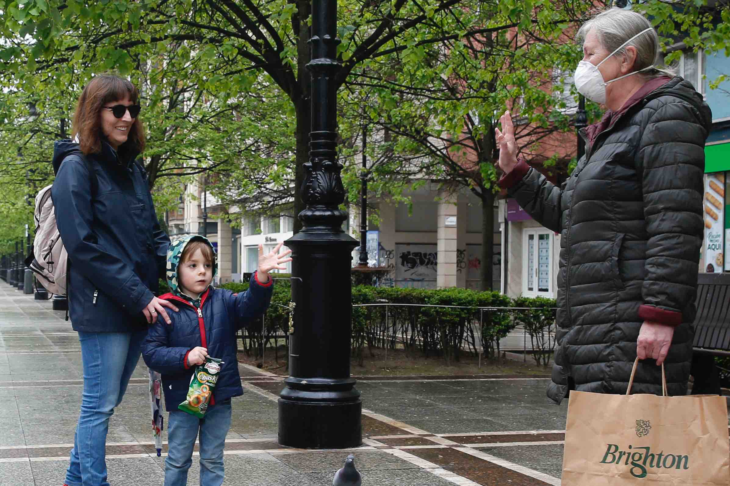 Primeros paseos bajo el orbayu en Gijón de los más pequeños