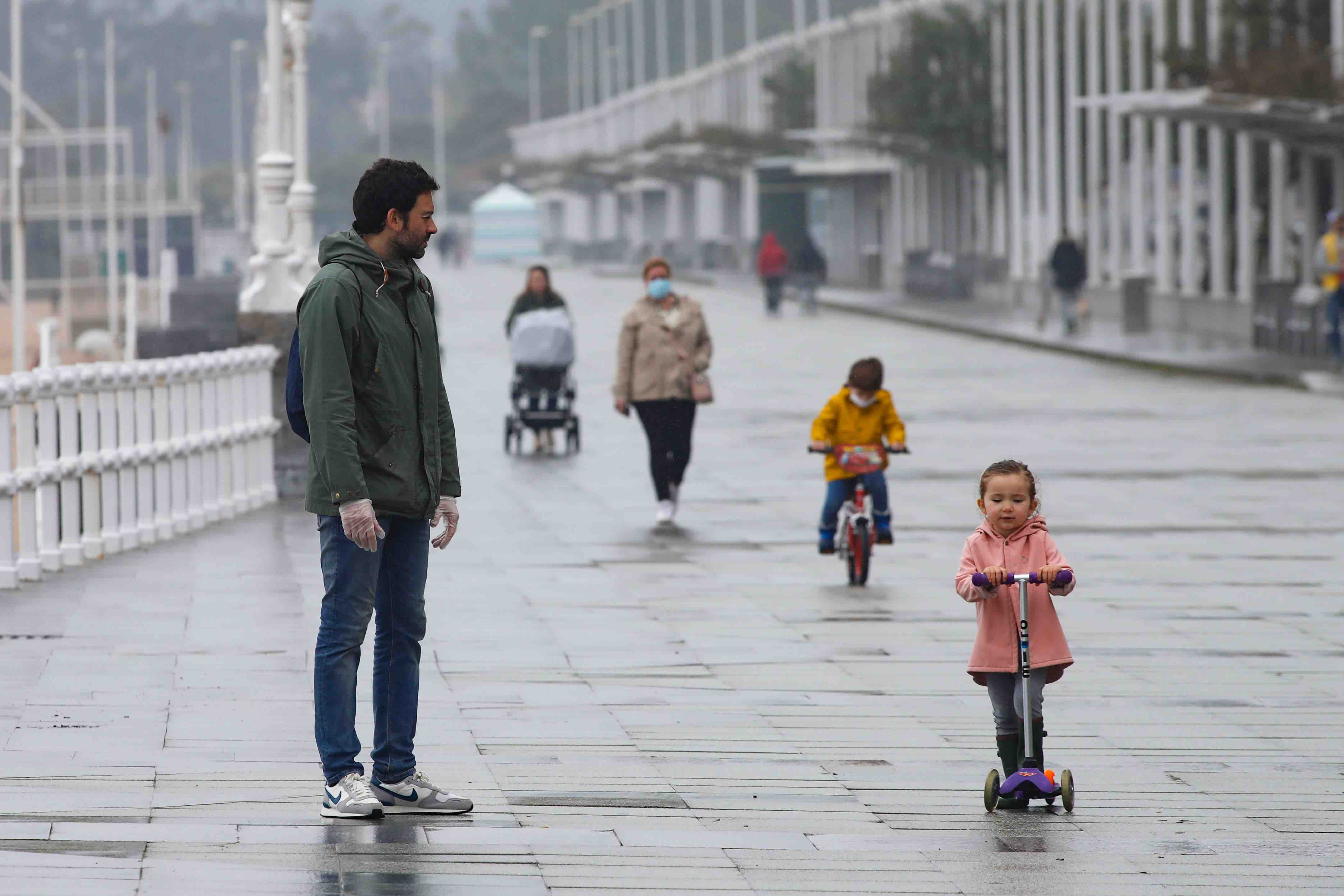 Primeros paseos bajo el orbayu en Gijón de los más pequeños