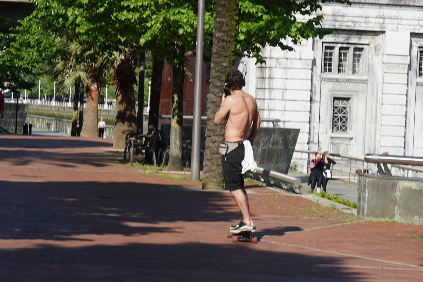 Un joven aprovecha el día soleado en Bilbao para montar en monopatín.